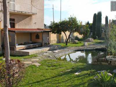 Il giardino zen con ghiaia, un laghetto, lanterne in granito e il tipico espositore giapponese